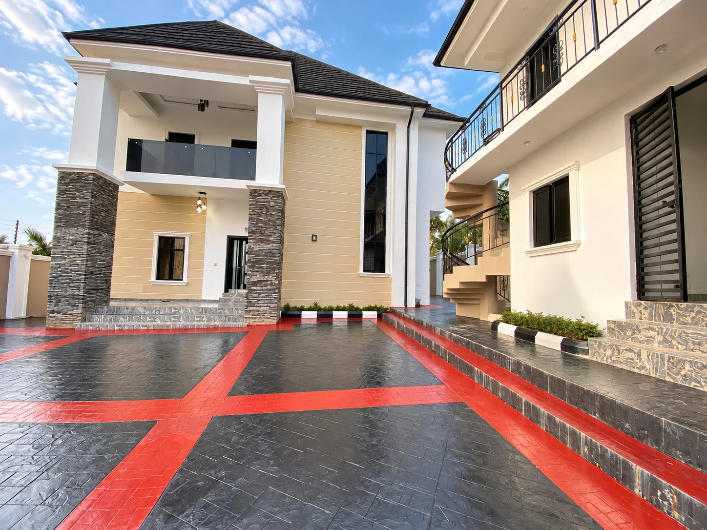 Completed residence and red-and-charcoal paved compound in Nigeria