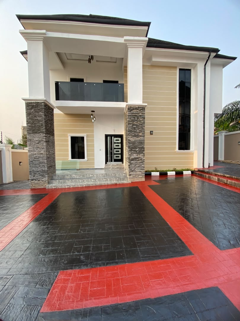 Completed residence with a stone-clad entrance and paved compound