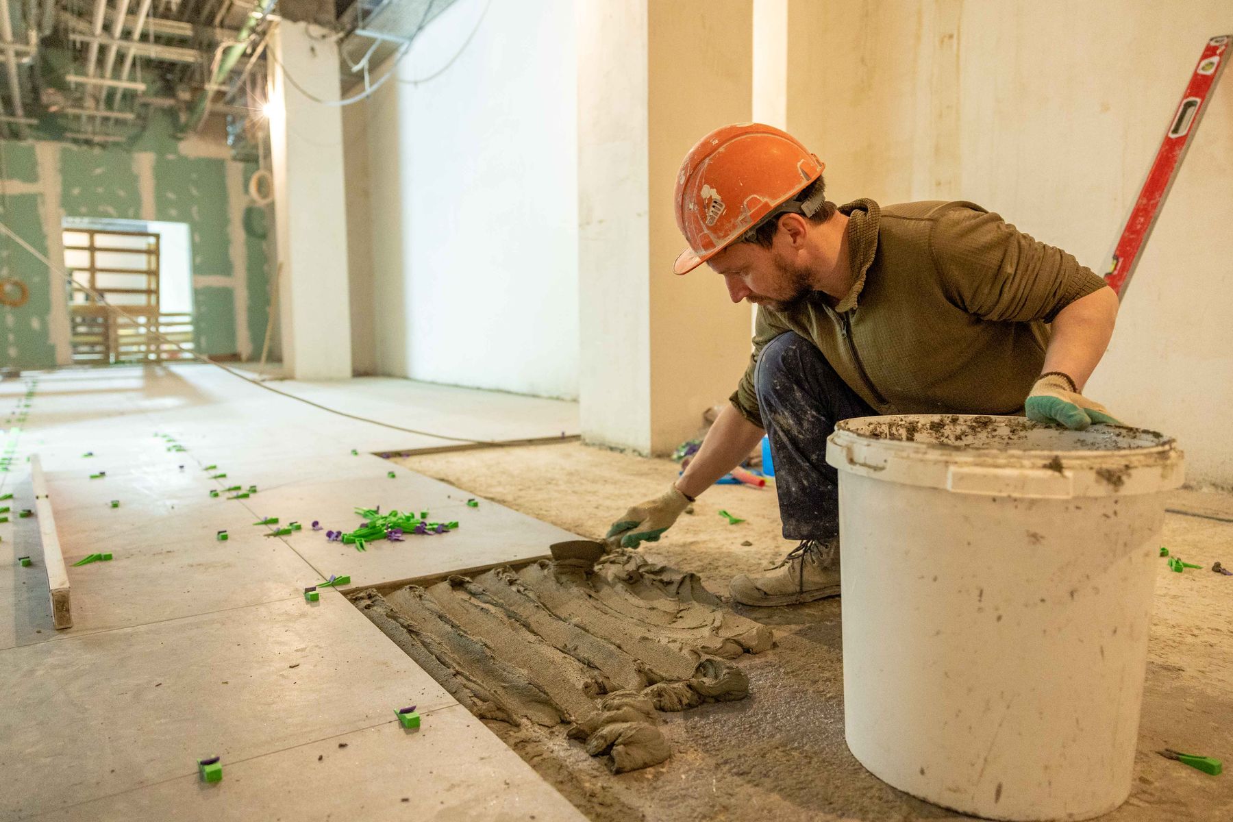 Craftsperson laying tile during an interior renovation