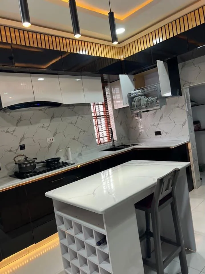 Black and white fitted kitchen with marble-look surfaces