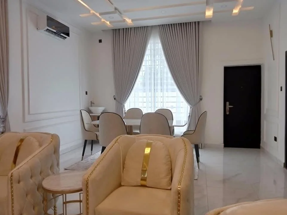 Finished living and dining area with cream seating and warm timber feature wall